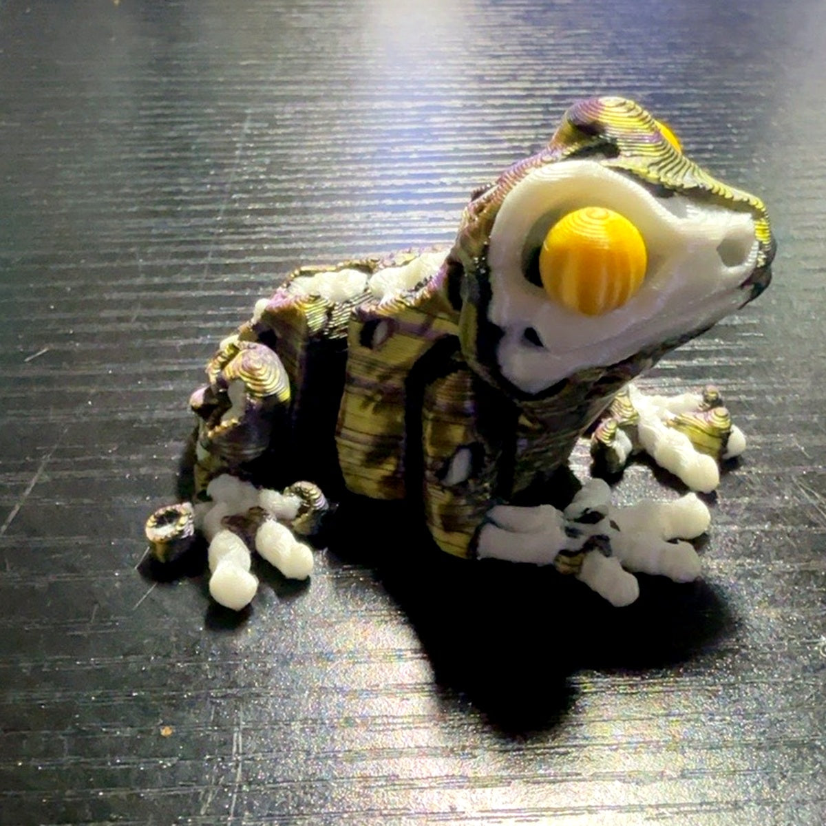 ZombieFrog articulated zombie frog in black with purple and gold swirl color scheme, alternate angle